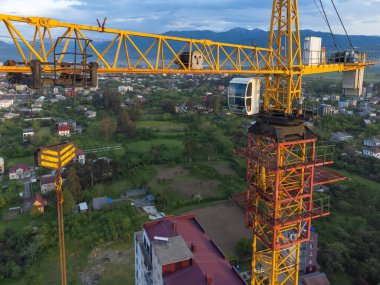 İnşaat vinç kabininin insansız hava aracının yakın görüntüsü güzel dağların arka planına karşı. İnşaat konsepti