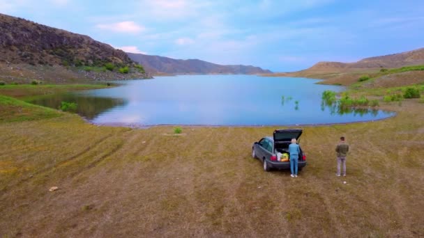 幸せな家族の車で2つの旅 アルメニアの山の中で湖によって道路上で休憩 自然の中で夜を過ごし 都会の喧騒から離れてください 車の中でカップルはすべてを戦利品 — ストック動画