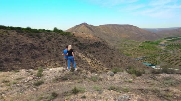 Pareja Joven Viajeros Enamorados Encuentra Borde Una Montaña Abraza Mira — Vídeos de Stock