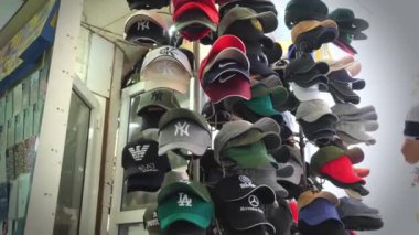 Batumi, Georgia - Mayıs 2023: Resmi mağazada ya da pazarda beyzbol şapkaları satılıyor. Çeşitli şirketlerin markalarını taşıyan beyzbol şapkaları.