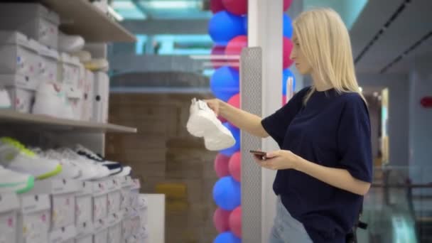 Güzel Genç Bir Kadının Portresi Mağazadan Yeni Ayakkabılar Alıyor Telefon — Stok video