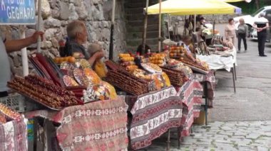 Erivan, Ermenistan - 5 Mayıs 2023: Genç gülümseyen kadın yemek standından soğuk buz kokteyli alıyor, masanın yanında duruyor ve kameraya bakıyor. Satıcıya seve seve para verir ve gülümseyerek gider..