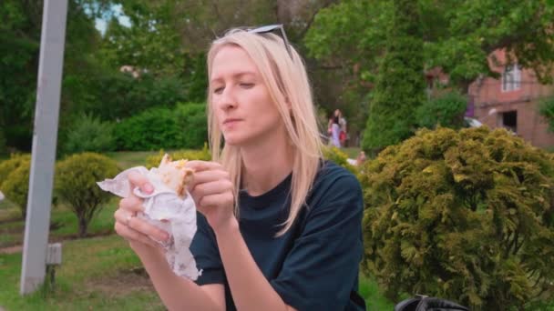 Zbliżenie Portret Szczęśliwej Młodej Blondynki Jedzącej Fast Food Shawarma Siedzącej — Wideo stockowe