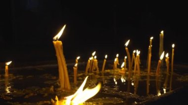 Hıristiyan Ortodoks kilisesi geçmişindeki mumlar. Tapınağın karanlık kutsal iç kısımlarında mum alevleri, kilisede yakılan anıt mumlar. Savaşın ya da kederin sembolü, olayların hatırası..
