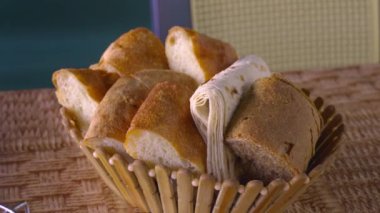 Restoranın içindeki masada farklı türde ekmek var. Kırsal kesimde sepette servis edilen ekmek dilimleri. Tahta sepette pide ve buğday ekmeği.