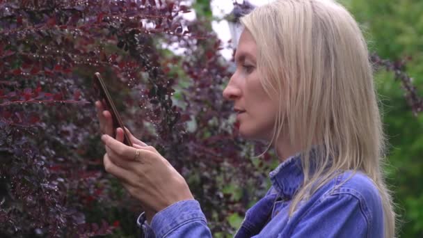 Молодая Женщина Джинсовом Костюме Фотографирует Камеру Мобильного Телефона Листья Экзотического — стоковое видео