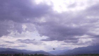 Havaalanından kalkan uçak, Georgia 'nın Batumi şehrindeki mavi gökyüzü, dağlar ve bulutlara karşı. Bilinmeyen havayolu şirketinin yolcu uçağı ufuktan uçtu..