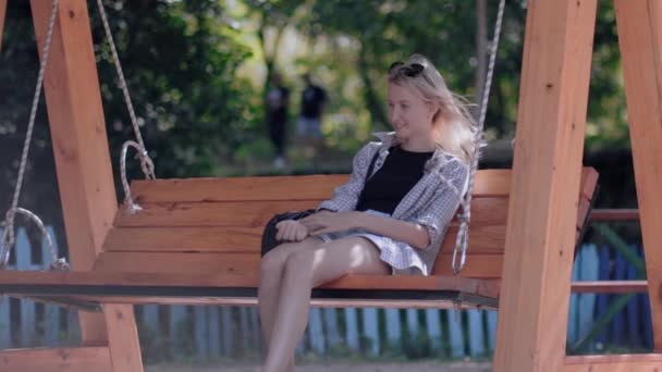 Cute Woman Sitting City Park Wooden Swing Suspended Chains Relaxing — Stock Video