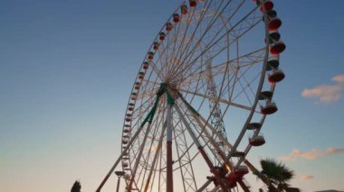 Georgia 'nın Tsitsinatela eğlence parkında parlak bir dönme dolap. Büyük dönme dolabın gece manzarası, döner ve akşam ışıklarıyla parlar..