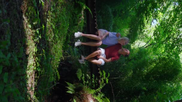 Άνθρωποι Άντρας Και Κορίτσι Κάθονται Μια Ξύλινη Γέφυρα Στο Δάσος — Αρχείο Βίντεο