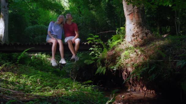 Ludzie Mężczyzna Dziewczyna Siedzący Drewnianym Moście Lesie Lubią Widoki Bajeczną — Wideo stockowe
