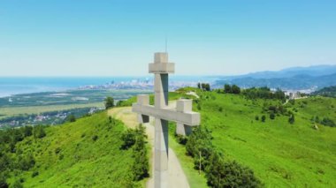 Ortodoks insansız hava aracının dağdan geçişi ile denizin arka planına yakın çekim. Özgürlükler, Hristiyanlık, Ortodoksluk. Georgia 'da Batumi' ye tepeden bakan dağlarda taş ya da beton geçidi. Dağlar