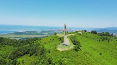 Ortodoks insansız hava aracının dağdan geçişi ile denizin arka planına yakın çekim. Özgürlükler, Hristiyanlık, Ortodoksluk. Georgia 'da Batumi' ye tepeden bakan dağlarda taş ya da beton geçidi. Dağlar