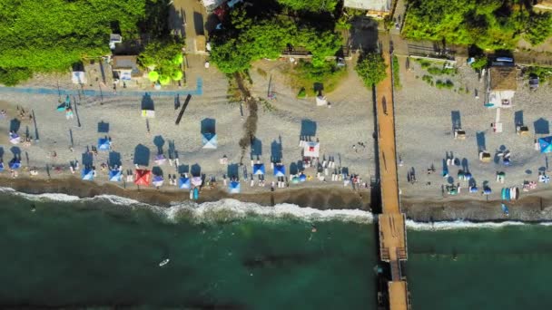 ビーチと傘の空中ビュー 行かないで ビーチとブルーウォーター ジョージア海岸のビーチとアジア海のドローンビュー ビーチ海岸線 夏の日 人々は泳ぎ 日光浴 — ストック動画