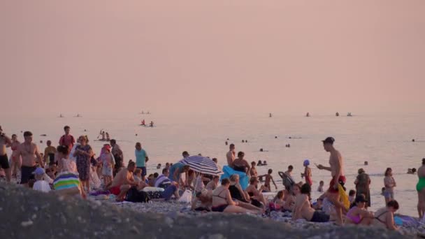 ジョルジュ2 2023 海の夕日を見ながらビーチに立っている大群衆 人々は泳ぎ 楽しんでいる たくさんの人が サンセット Supに乗っている人 海の残り — ストック動画