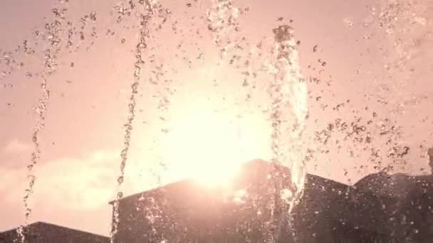 日差しで晴れた日の噴水のスプラッシュ 噴水の水滴のゆっくりとした動き シティパーク 夏の暑さと上昇温度 — ストック動画
