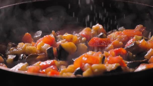 ロースト野菜を調理する シェフは熱い鍋を蒸すために塩を加えます アジア料理かベジタリアン料理 シェフはフライパンに野菜シチューを用意しています 増加する 返された動き — ストック動画