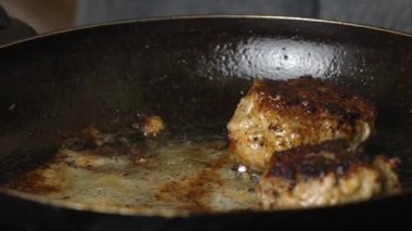 Et köftesi ya da pirzola şeklinde köfte kızartma tavasında yağda kızartılıyor, yakın çekim. Pirzolaların Rusça ya da Lehçe versiyonu: kotlety. Ev yemeği, kıymalı ekmek..