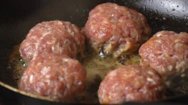 Et köftesi ya da pirzola şeklinde köfte kızartma tavasında yağda kızartılıyor, yakın çekim. Pirzolaların Rusça ya da Lehçe versiyonu: kotlety. Ev yemeği, kıymalı ekmek..