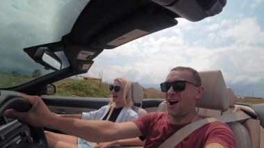 Güzel bir çift ve kız üstü açık arabayla yüksek hızda gidiyorlar. Hızı ve ivmeyi yakalarlar, duygusal olarak bağırırlar ve sevinirler. Kiralık arabayla tatil.