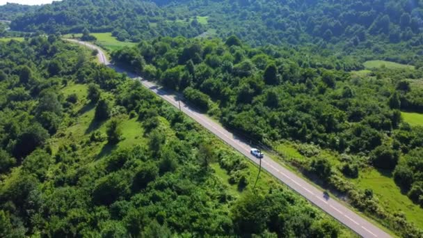 阳光明媚的夏天 在佐治亚州山区的森林里 敞篷车沿着乡间小路行驶的空中风景 电影中的无人机捕捉到美丽空旷的道路上的照片 相机在车后飞舞 — 图库视频影像