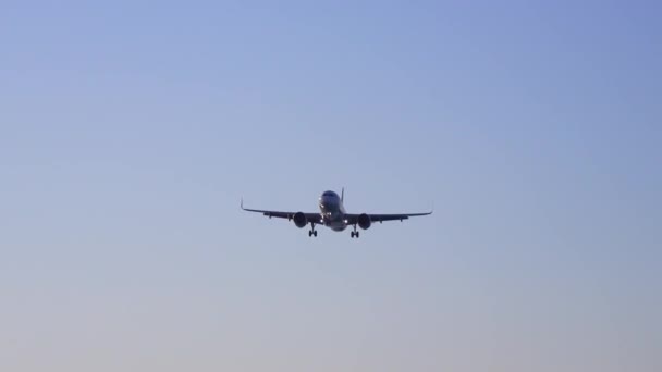 飞机降落在五彩斑斓的蓝天上 风景与飞机在蓝天与橙色和粉红色的云 乘坐客机旅行的背景 商业飞机 私人喷气式飞机 — 图库视频影像