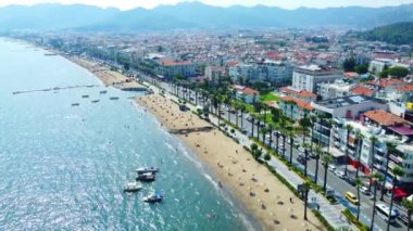 Türkiye 'nin Marmaris kentinde gün batımında hava manzarası ve güzel mimari. Marina Körfezi 'ndeki oteller, evler, plajlar, parklar ve tekneler ve dağlarla dolu renkli bir manzara. Limanın insansız hava aracı görünümü