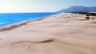 Yaz deniz manzarası, güzel dalgalar, güneşli bir günde mavi deniz suyu. İHA 'nın üst görüntüsü. Deniz manzarası, kurutulmuş kumullar ve Patara sahilindeki hindi kumulları. Dağlar ve güzel manzaralar.