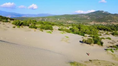 Patara sahilindeki kum tepelerinde yürüyen mutlu yolcuların insansız hava aracı görüntüleri. Gezginlik, seyahat ve sosyal medya içeriği. Hindi. Yüksek kum tepeleri olan büyük bir çöl. Isı.