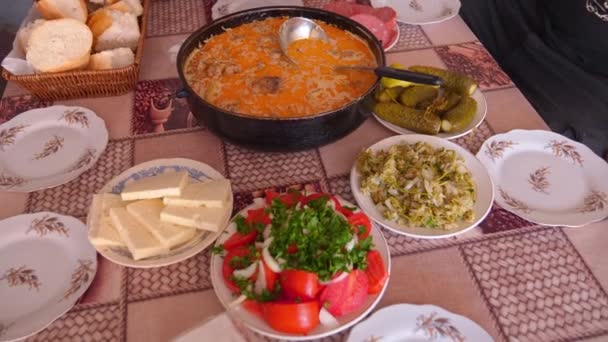 ジョージアのキッチンの木製テーブルのトップビュー 伝統的なグルジア料理と料理 キュウリとトマトサラダ チーズ チカプリ チカペリ チカパプリ 村の国テーブル — ストック動画