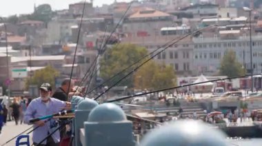 ISTANBUL, TURKEY - SEPTEMBER 5, 2023: Galata Köprüsü 'ndeki balıkçılar İstanbul' un arka planı, İstanbul 'un eski yarımadası, Zlotoi bölgesinin güzel panoramik manzarası veya Boğaz' da balık avlıyorlar.