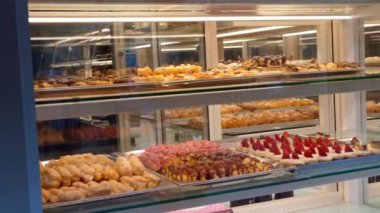 Pasta dükkanının vitrininde kremalı pasta ya da pastanede kremalı pasta çeşitliliği olan bir vitrin. Böğürtlenli tatlı hamur işleri. Şekerleme Gösterisi.