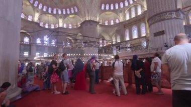 STAMBUL, TURKEY - SEPTEMBER 4, 2023: Mavi Cami 'nin İçi (Sultan Ahmed Camii) dekoratif mavi ve beyaz mozaikli, boyanmış fayanslar, pencereler ve müslüman insanlar.