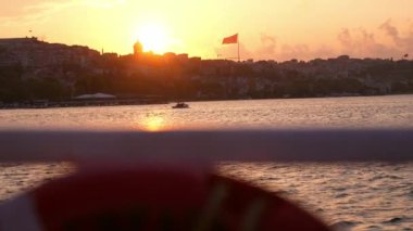 Gemi, yat ya da tekneden güverte ve korkuluklar. Güzel gün batımı ve okyanus manzarası, Türkiye 'de İstanbul' u bayrakla gören Boğaz. Gün batımında sakin denizde hareket eden yavaş çekim güvertesi teknesi.