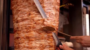 Shawarma için et ve tükürük. Izgara et. Yemek pişirmek. Şefin Bıçağı Geleneksel Türk Et Donörü Kebabı. Shawarma veya jiroskop. Yunan ya da Orta Doğu tarzı Tavuk Döner Kebap
