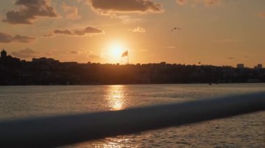 Gemi, yat ya da tekneden güverte ve korkuluklar. Güzel gün batımı ve okyanus manzarası, Türkiye 'de İstanbul' u bayrakla gören Boğaz. Gün batımında sakin denizde hareket eden yavaş çekim güvertesi teknesi.