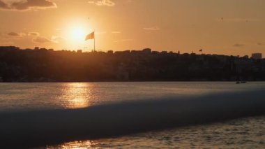 Gemi, yat ya da tekneden güverte ve korkuluklar. Güzel gün batımı ve okyanus manzarası, Türkiye 'de İstanbul' u bayrakla gören Boğaz. Gün batımında sakin denizde hareket eden yavaş çekim güvertesi teknesi.
