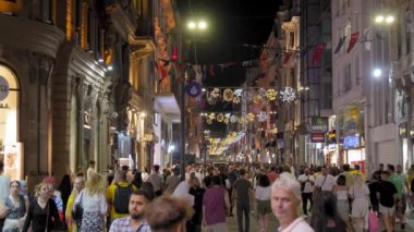 İstanbul 'daki İstiklal Caddesi manzarası, sokakta yürüyen sıradan insanlar. Fotoğraf çeken turistler. Şehrin eski semtindeki Mogazinler. Turistlerin ilgi odağı. Bir sürü insan geziyor..