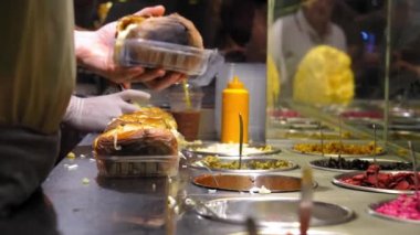 Aşçı Kumpir restoranında hazır - geleneksel Türk yemeği fırında patates, tereyağı, peynir ve sebzeli. Türk sokak yemeği Kumpir. Peynirli fırında patates, mısır, sosis, ketçap.