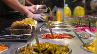 Aşçı Kumpir restoranında hazır - geleneksel Türk yemeği fırında patates, tereyağı, peynir ve sebzeli. Türk sokak yemeği Kumpir. Peynirli fırında patates, mısır, sosis, ketçap.