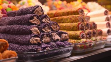 Türk Şekerlemeleri Şovu Arap sokak pazarının tezgahında geniş çeşitlilik, baklava ve fındıklı Türk lokumu.