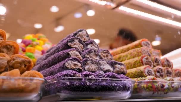 トルコの菓子ショーケース広い品揃えのアラブのストリートマーケットのカウンターのさまざまなスイーツ バクラバ ナッツとのトルコの喜び — ストック動画
