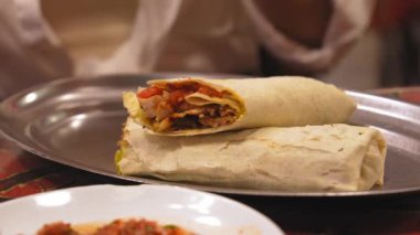İstanbul 'da Türkiye' de turistik bir yer olan kafede servis edilen tabağın üzerinde et, sebze salatası ve sos bulunan Durum doner kebabı veya shawarma. Lezzetli Türk Sokak Yemekleri Fast Food.