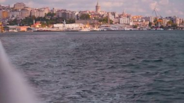 Gemi, yat ya da tekneden güverte ve korkuluklar. Günbatımı ve okyanus manzarası güzel, İstanbul 'da İstanbul Boğazı görünüyor. Gün batımında sakin denizde hareket eden güverte teknesinin yavaş çekimi.