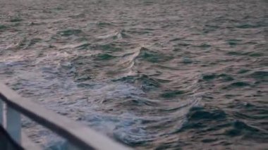 Güverte manzarası ve denizde giden ahşap tekne manzarası. Gemi derin mavi denizin köpüklü beyaz dalgalarını kesiyor. Beyaz köpüklü, hareket eden pervane motorundan çıkan beyaz köpük