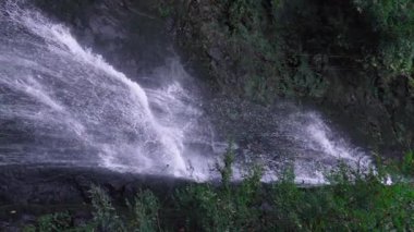 Tropik bir manzara. Yağmur ormanlarında saklı güzel bir şelale. Macera ve seyahat konsepti. Doğanın Tarih Öncesi. Hareketli çekim. dikey video yavaş çekim