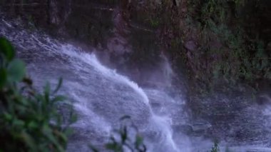 Tropik bir manzara. Yağmur ormanlarında saklı güzel bir şelale. Macera ve seyahat konsepti. Doğanın Tarih Öncesi. Hareketli çekim. dikey video