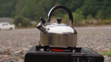 Metal su ısıtıcısı gaz ocağında buharla kaynıyor ve duruyor. Ki bu da doğadaki gaz ocağının üzerinde duruyor..