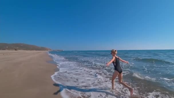 뜨거운 햇빛의 해변에서 휴식을 취하고 순간을 즐기는 수영복에 Carefree 그녀는 — 비디오