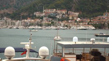 Türkiye 'de Fethiye sahili manzarası. Fethiye, Türk Rivierası 'nda popüler bir turizm beldesi. Yatlar ve yelkenliler, yaz mevsimi Marina 'sında turkuaz sularda demirlemişti. Liman ve yat manzaralı Fethiye Mugla